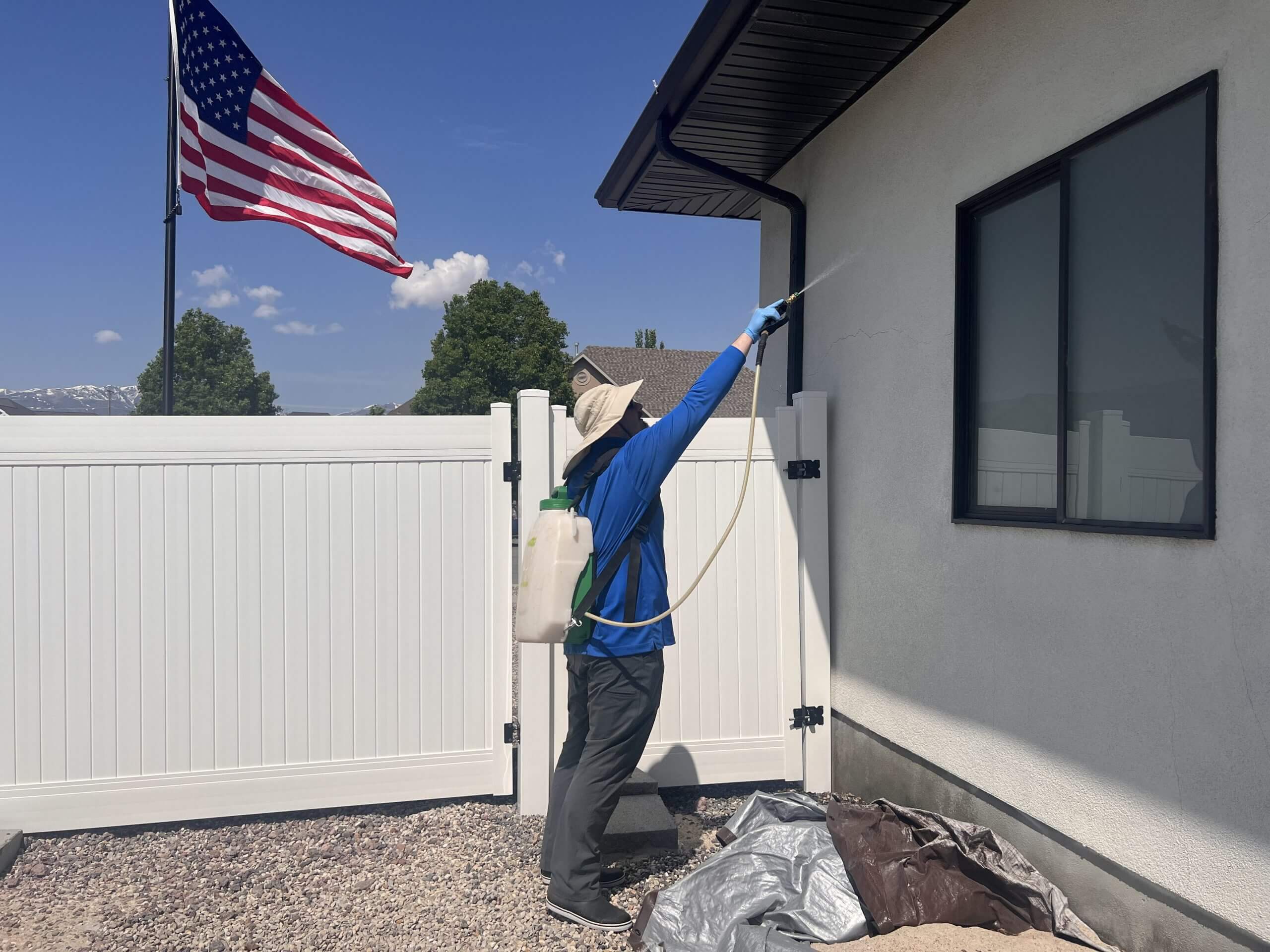 Pest Control tech Spraying house on the right side