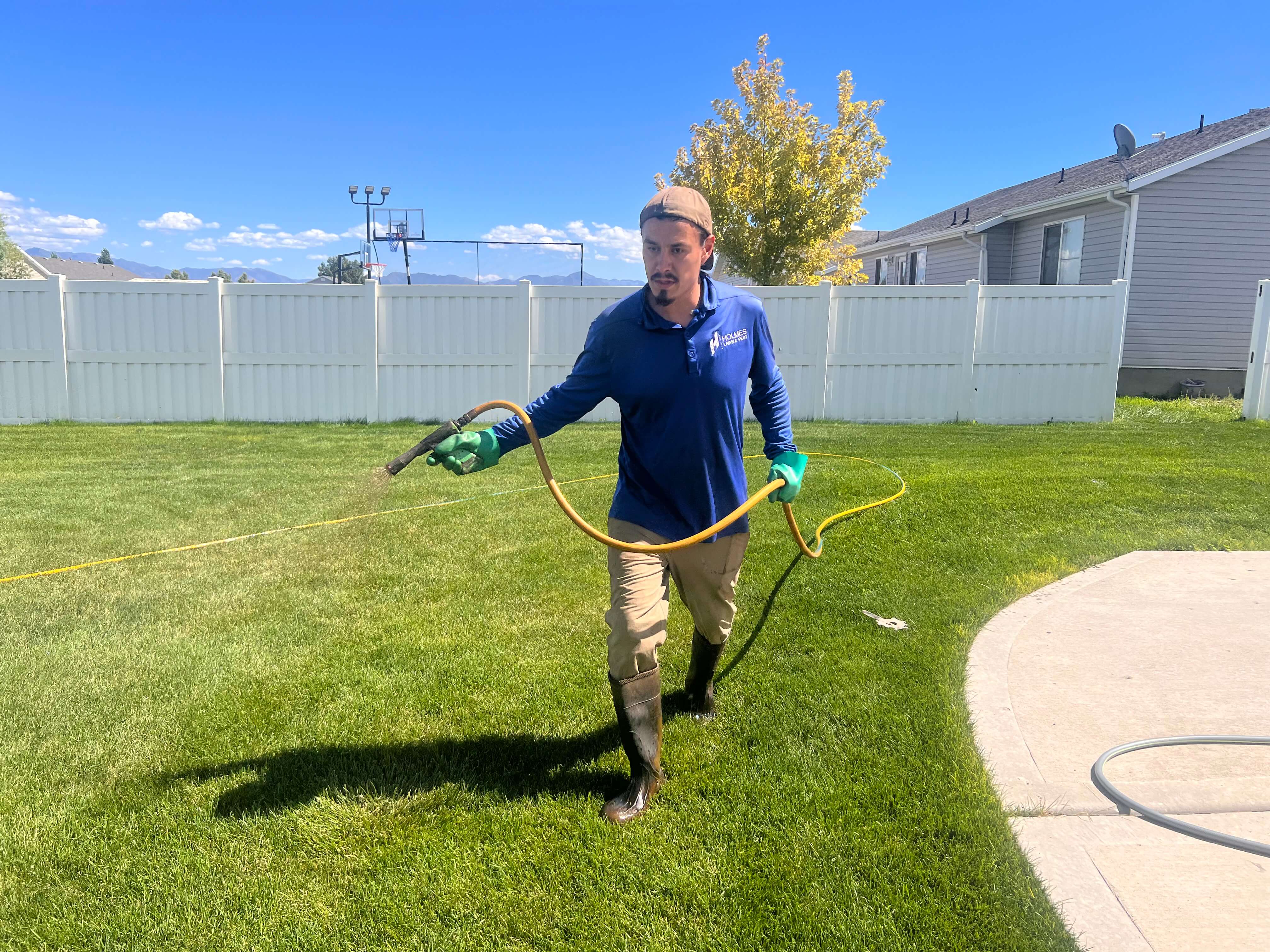 employee tech spraying on grass