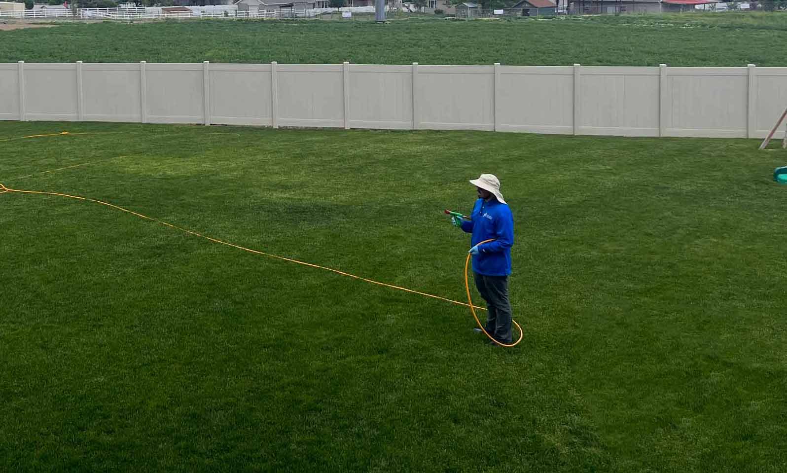 holmes spraying an outdoor lawn rectangle scaled small
